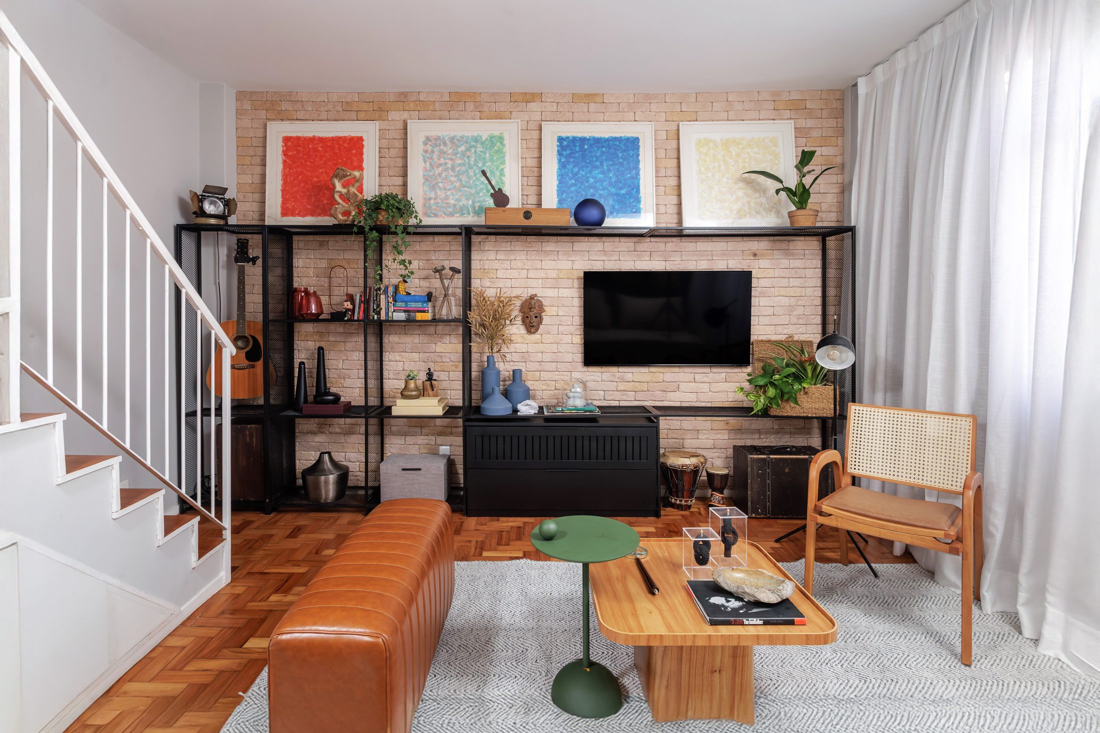 Ambiente integrado com mobiliário, arte e objetos compostos de forma equilibrada